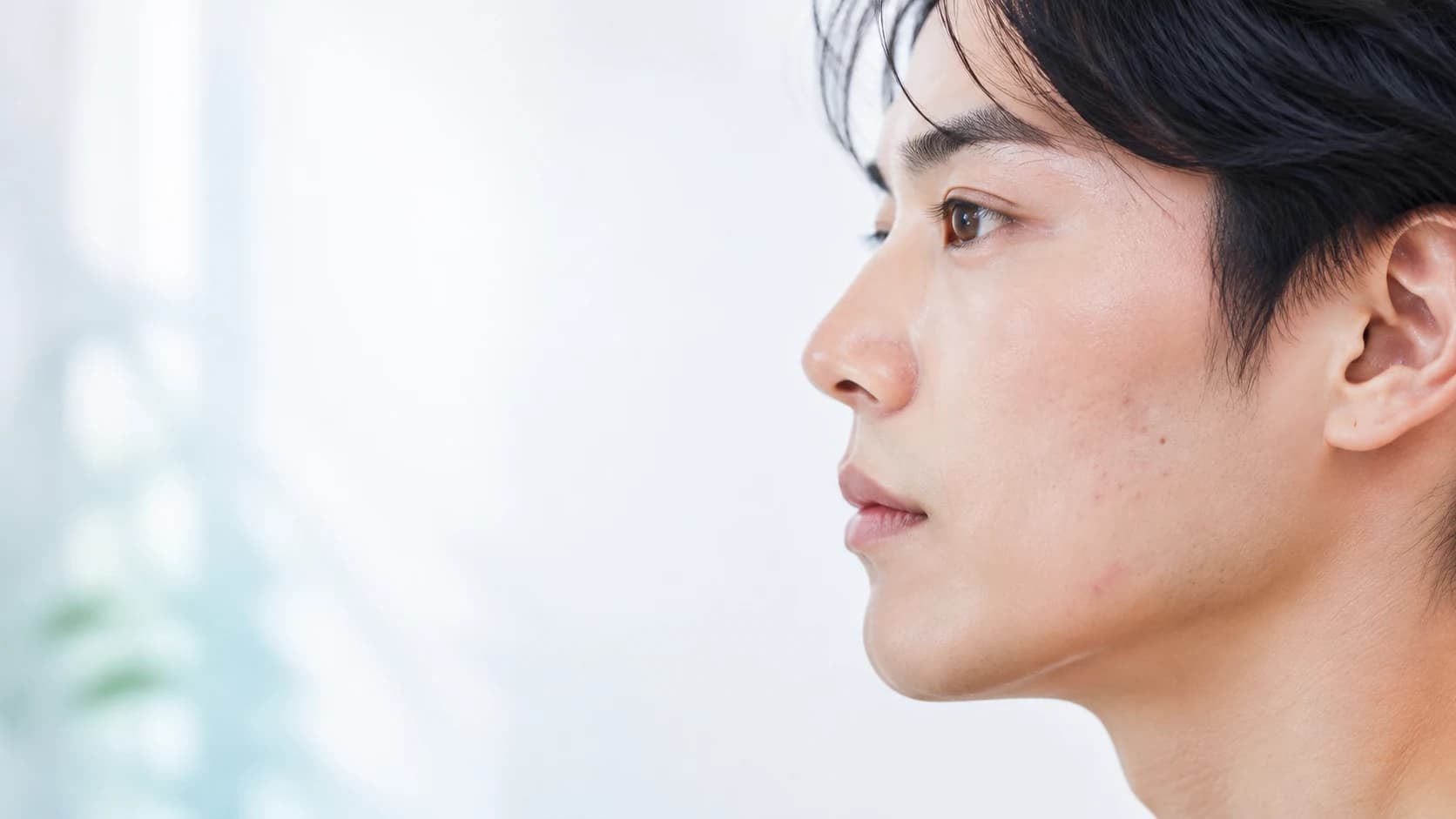 성인 얼굴 피부의 가벼운 여드름을 절제된 방식으로 표현한 의료 에디토리얼 이미지